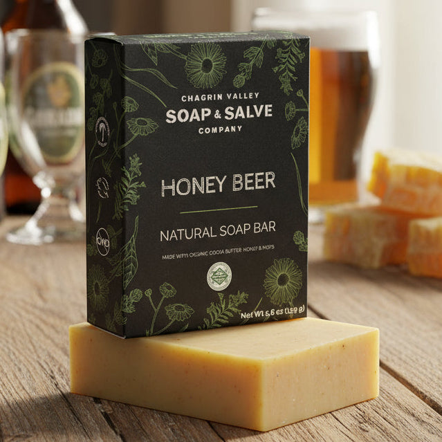 Box of Chagrin Valley Soap & Salve Company Honey Beer soap bar on a wooden table with beer bottles and glasses in the background.