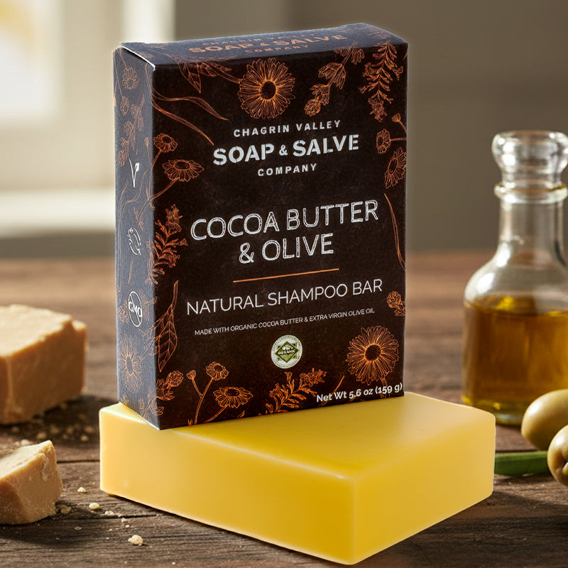 Cocoa Butter & Olive natural shampoo bar with packaging on a wooden surface.